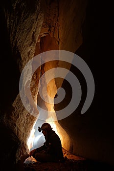 Cave passage with a caver photo