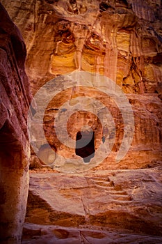 Cave in red sandstone wall, Petra, Jordan