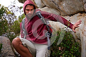 Cave, rock climbing and man hiking in mountain with backpack for adventure for wellness in trip. Earth, fitness and male