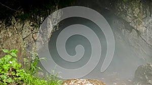 Cave in rock with fog. Stock footage. Large input into dark fog-filled cave brings fear to unknown. Thick fog envelops