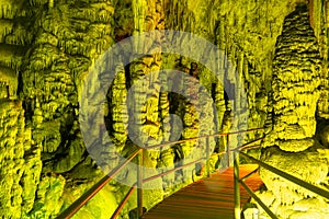 Cave rock formations are stalactites and stalagmites in colorful light. The miracle of the formation of stalagmites in