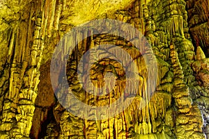 Cave rock formations are stalactites and stalagmites in colorful light. The miracle of the formation of stalagmites in the dark