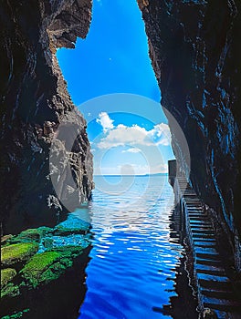 A cave with stairs leading to the water