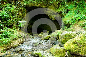 Cave and water cascades in wilderness photo