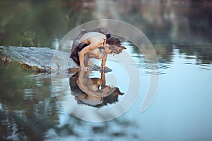 Caveman. Little boy sitting on the beach and looks at the water