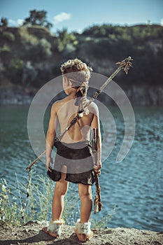 Caveman, manly boy with stone axe and bow hunting