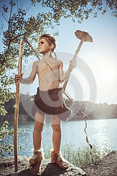 Caveman, manly boy with stone axe and bow hunting