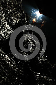 Caver descends in a cave