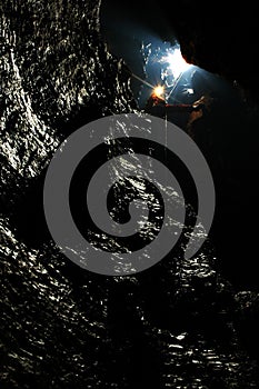 Caver descends in a cave photo