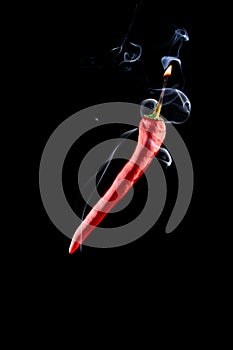 Cayenne chilli. Red hot chili paprika with hell flame, white smoke or spicy chile cayenne pepper isolated on black