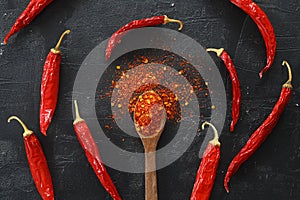 cayenne pepper on wooden spoon spices and dried chilli peppers background