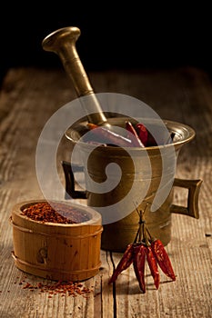 Cayenne pods in pounder and milled pepper photo