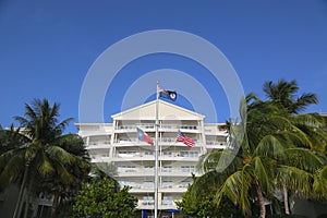 Cayman Islands, United States and State of Texas flags in the front of luxury resort located on the Seven Miles Beach