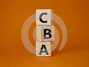 CBA - Cost Benefit Analysis symbol. Wooden cubes with word CBA. Beautiful orange background. Business and Cost Benefit Analysis photo