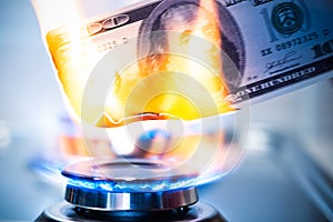 CBurning bill of hundred American US dollars on a gas burner flame