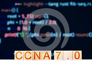 ccna 7.0 concept. wooden blocks labeled ccna 7.0 Cisco Certified Network Associate and program code in the background.
