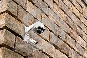 A CCTV camera is installed on a stone wall.