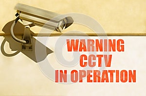 A CCTV camera is installed on the wall of the building, next to it is written - Warning CCTV in operation