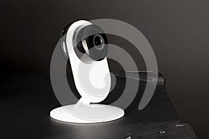 CCTV camera lens, security camera on a black background in a room on furniture, close-up, selective focus