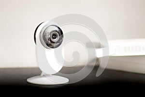 CCTV camera lens, security camera on a white background in a room on furniture, close-up, selective focus