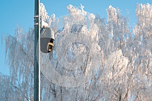 CCTV camera on metal pole in public park, cold winter season