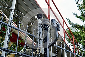 CCTV camera and motion detectors on the fance with barded wire