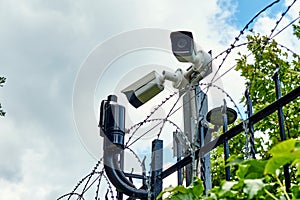 CCTV camera and motion detectors on the fance with barded wire