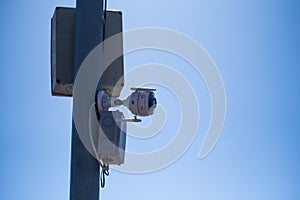 CCTV camera on pole with blue sky background, security concept