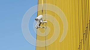 CCTV cameras on facade of industrial building on hot summer day. Building