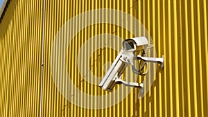 CCTV cameras on facade of industrial building on hot summer day. Building