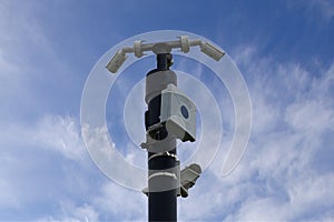 CCTV cameras on mast , blue sky with few clouds background.