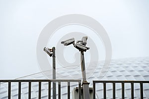 CCTV cameras mounted on a pole. Professional security cameras scan the street. Surveillance, privacy, crime, technology