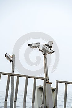 CCTV cameras mounted on a pole. Professional security cameras scan the street. Surveillance, privacy, crime, technology