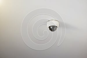 CCTV security camera mounted on a white ceiling.