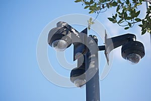 CCTV security camera operating outdoor against blue sky