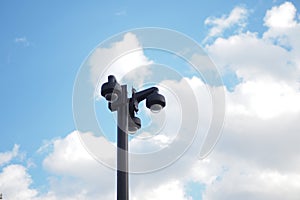 CCTV security camera operating outdoor against blue sky