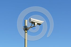 CCTV camera on pole on clear blue sky background for law and order
