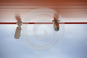 CCTV security cameras on pole on blue sky with white clouds background Limited depth of field