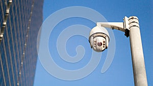 CCTV surveillance security camera on pole in city with tower building background for safety system area control outdoor and copy