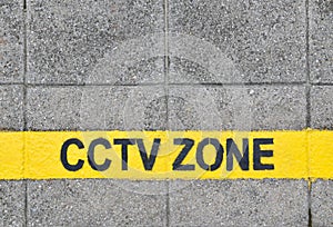 cctv zone text in yellow horizontal line paint on concrete tiles sidewalk