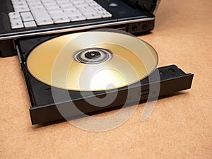 CD DVD optical disc media inserted in a laptop computer disc tray, closeup, nobody. Films, movies software data storage