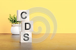 cds - text on wood cubes stack, yellow background