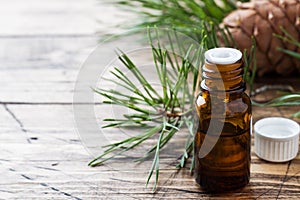 Cedar and spruce essential oil in small glass bottles on wooden background. Selective focus.