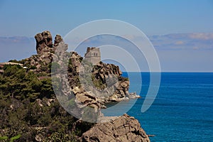 Cefalu Castle or Rocca della Cefalu, near Palermo in Sicily. Ancient ruins on a headland with deep blue sea and sky background