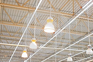 Ceiling with bright lamps in a modern warehouse. Image of bright light, a large space for trade, storage, commercial activity