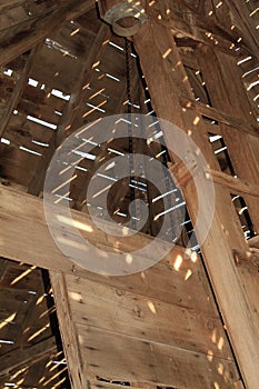 Ceiling of a collapsing wooden farm building with sunlight and shadow patterns
