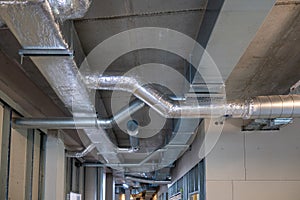 On a ceiling of a construction site runs heating and ventilation pipes