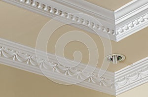 Ceiling decoration with plaster cast and embed lamp in ceiling panel. Eclectic interior design. Architectural detail.