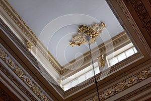 Ceiling illuminated by clerestory windows to reveal elaborate cornice and frieze work, abundant gold leaf