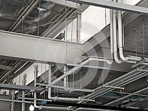 The ceiling of a large building under construction an extensive network of pipes